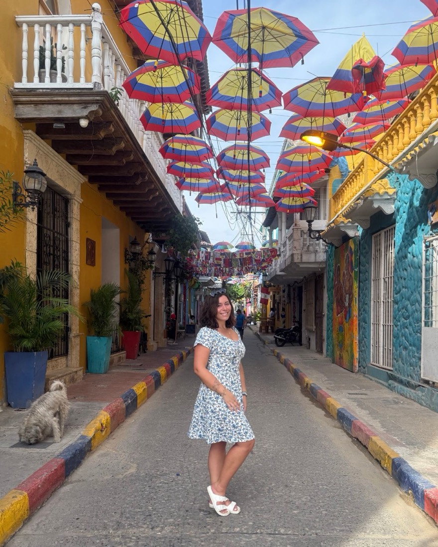 Audrey dans une rue colorée de Carthagène, sous des parapluies aux couleurs de la Colombie