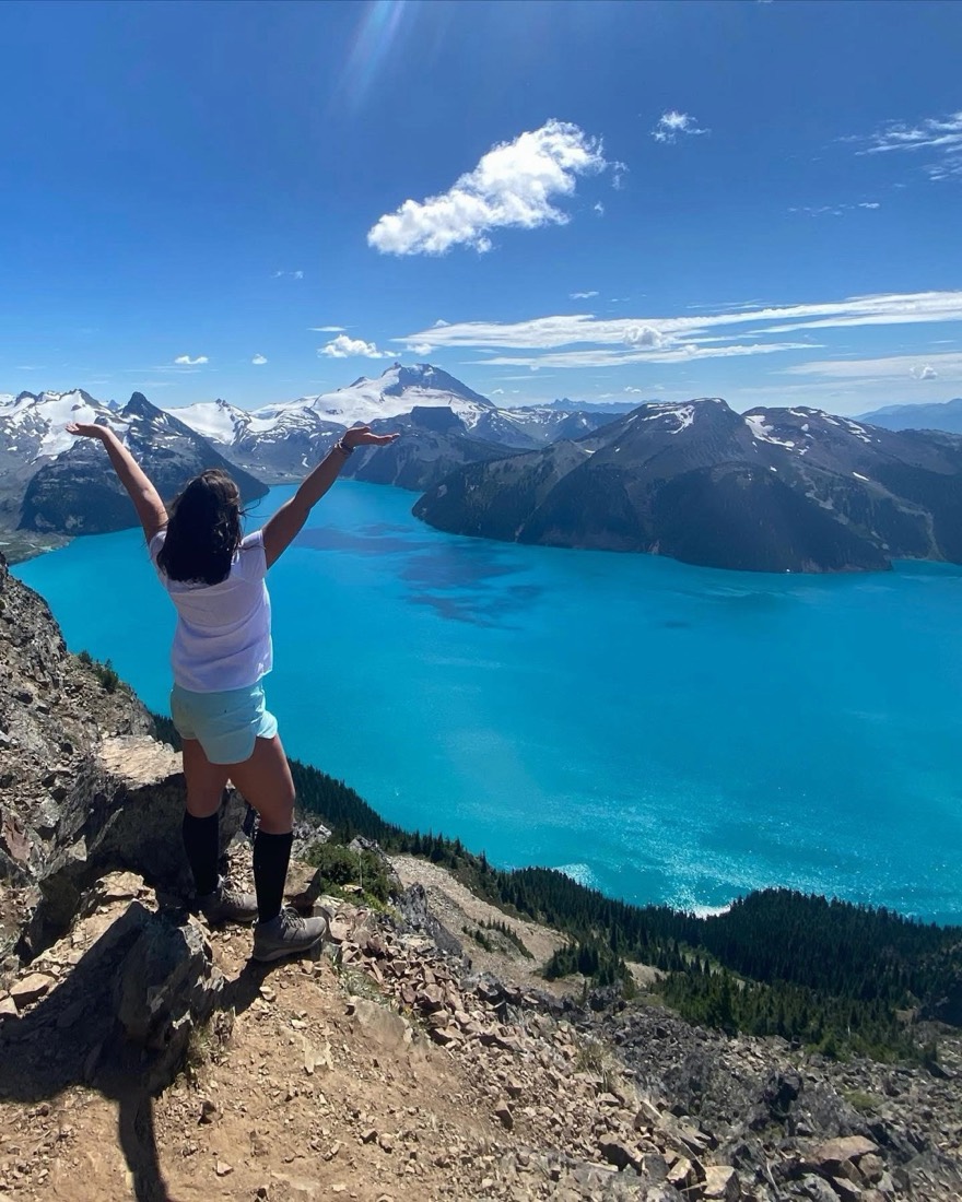 Audrey, bras levés, devant le lac Garibaldi en Colombie-Britannique